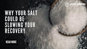 Three types of salt—refined white, pink Himalayan, and sea salt—in wooden spoons on a neutral background.